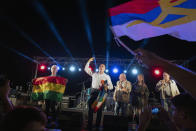 El candidato presidencial uruguayo del oficialista Frente Amplio, Daniel Martinez, segundo desde la izquierda, y Graciela Villar su compañera de fórmula, que carga una bandera Whiphala, habla después de un evento cultural en Montevideo, Uruguay, el martes 19 de noviembre de 2019. (AP Foto/Matilde Campodonico)