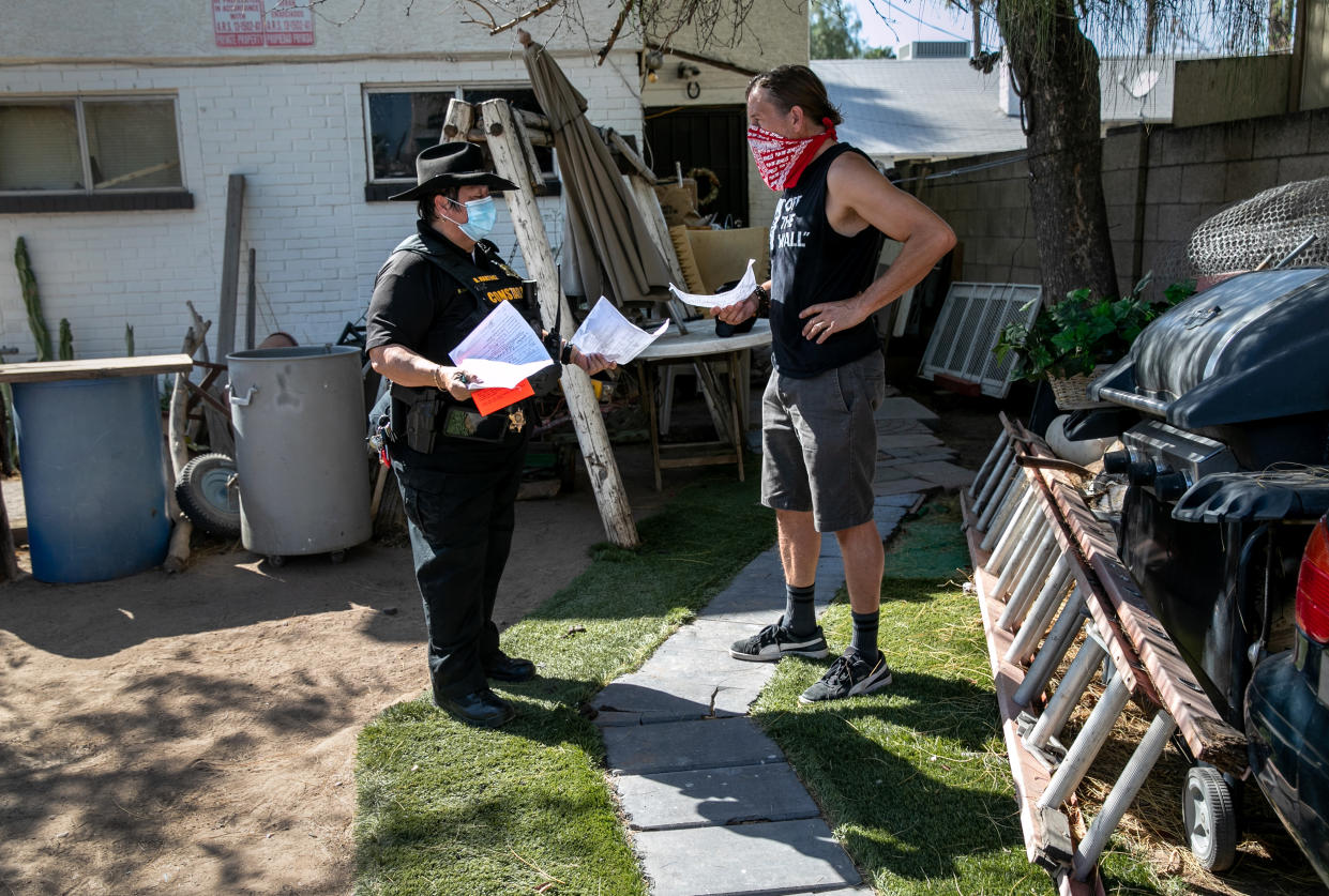 PHOENIX, ARIZONA - SEPTEMBER 30: Maricopa County constable Darlene Martinez speaks with a landlord after arriving to evict a family for non-payment of rent on September 30, 2020 in Phoenix, Arizona. Thousands of court-ordered evictions continue nationwide despite a Centers for Disease Control (CDC) moratorium for renters impacted by the coronavirus pandemic. Although state and county officials say they have tried to educate the public on the protections, many renters remain unaware and fail to complete the necessary forms to remain in their homes. With millions of Americans still unemployed due to the pandemic and federal rental assistance proposals gridlocked in Congress, the expiry of the CDC moratorium at year's end looms large, as renters confront eviction and landlords face a potential wave of foreclosures.  (Photo by John Moore/Getty Images)