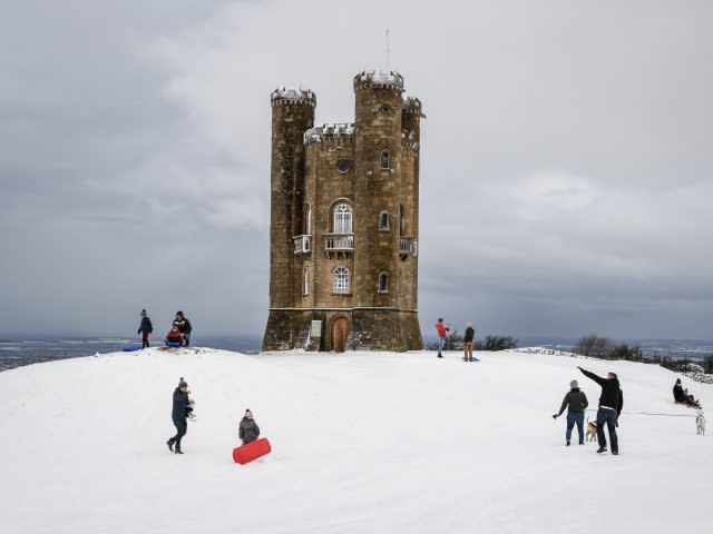 People enjoy the snow at Broadway Tower on the Cotswold hills, Worcestershire (PA)