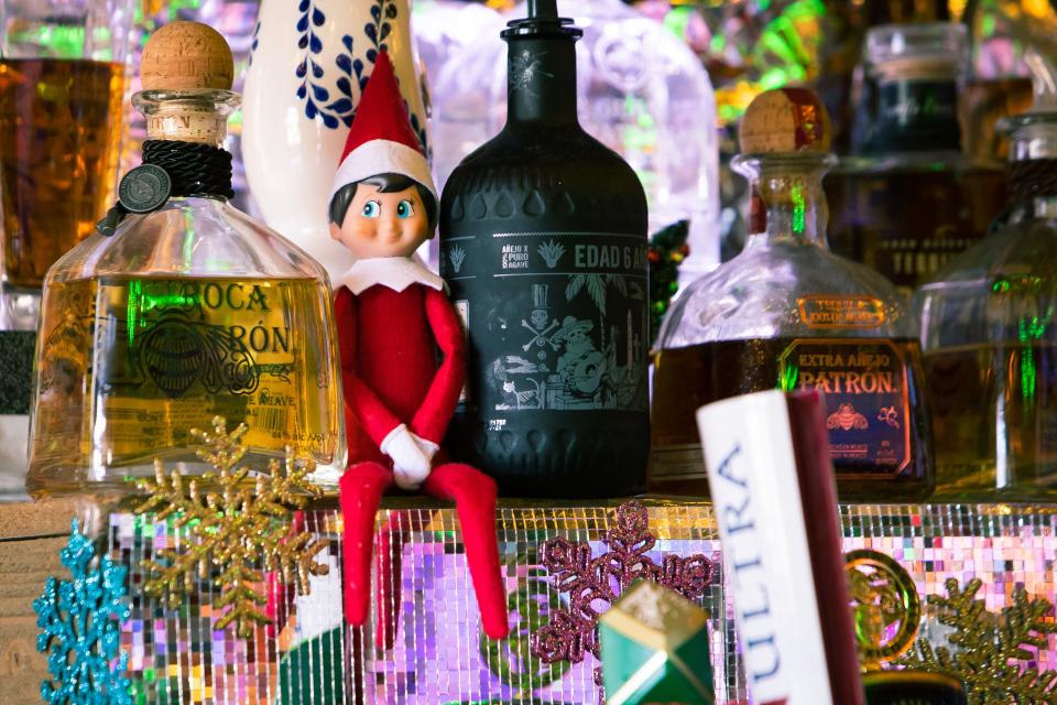An "elf on the shelf" doll sits next to bottles of tequila behind the ber at Salt and Lime after decorations transform it into the Feliz Navidad Cantina for the holidays on Nov. 29, 2021, in Scottsdale.