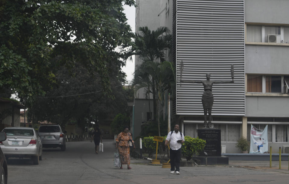 People walk past the Faculty of law department of the University of Lagos in Nigeria, Wednesday Aug. 17, 2022. A strike declared by lecturers in Nigerian public universities has now clocked six months, hurting an estimated 2.5 million students who do not have other means of learning. Such strikes are common in this West African nation with more than 100 public universities. (AP Photo/Sunday Alamba)