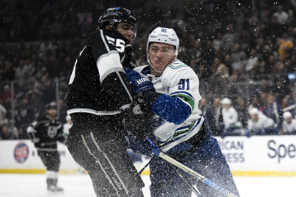Vancouver Canucks defenseman Nikita Zadorov (91) checks Los Angeles Kings right wing Quinton Byfield (55) during the second period of an NHL hockey game Tuesday, March 5, 2024, in Los Angeles. (AP Photo/Kyusung Gong)