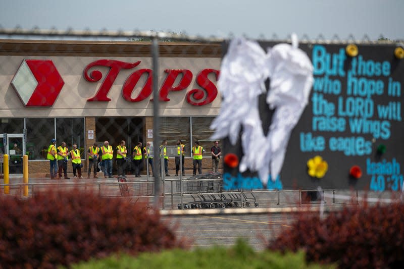 Investigators stand outside during a moment of silence for the victims of the Buffalo supermarket shooting outside the Tops Friendly Market on May 21, 2022, in Buffalo, N.Y. 