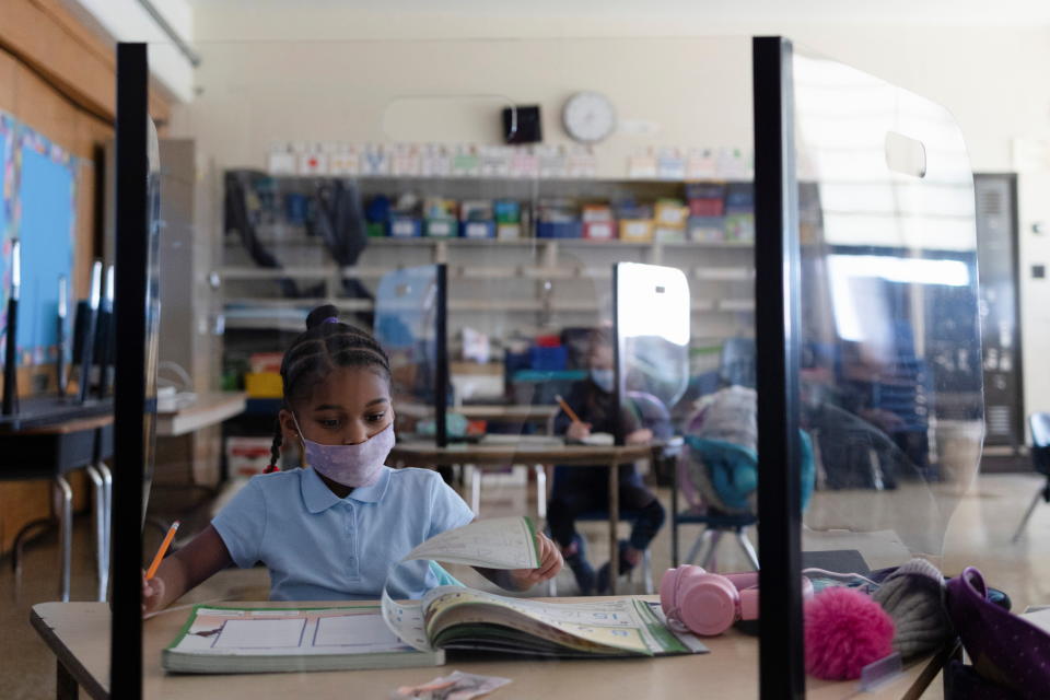 A girl attends school from a booth as students return to school as coronavirus disease (COVID-19) restrictions are lifted in Philadelphia, Pennsylvania on March 8, 2021. (Hannah Beier/Reuters)