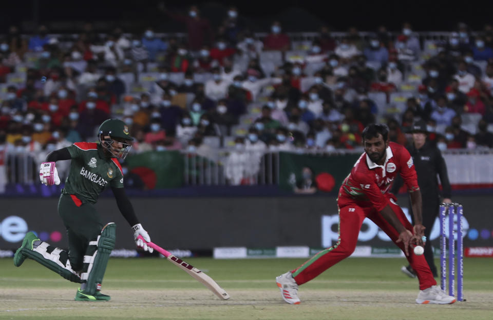 Bangladesh's batsman Mushfiqur Rahim, left, runs and survives a run out attempt by Oman's Mohammad Nadeem during the Cricket Twenty20 World Cup first round match between Oman and Bangladesh in Muscat, Oman, Tuesday, Oct. 19, 2021. (AP Photo/Kamran Jebreili)