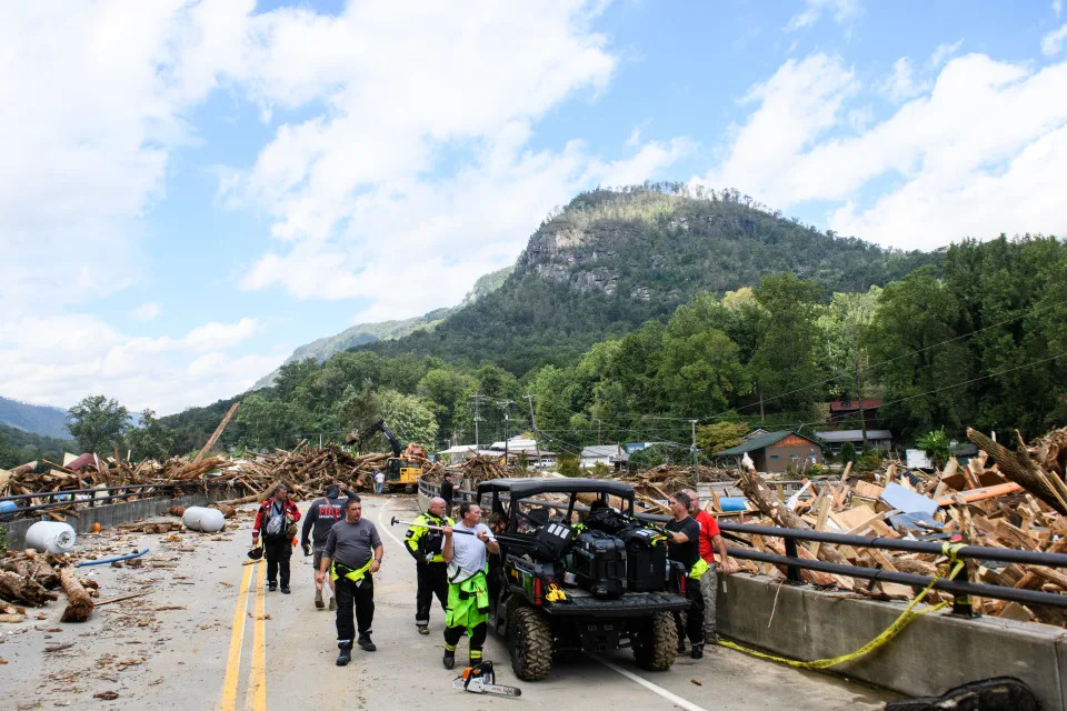 Emergency personnel are observed on a road as the Rocky Broad River merges into Lake Lure, carrying debris from Chimney Rock, N.C., after heavy rains caused by Hurricane Helene on Sept. 28.