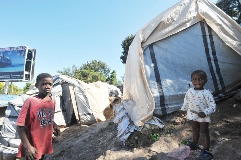 Children stand in front of the tent they call home, in Canape-Vert, Haiti, on December 21, 2012. While people around the world celebrate the arrival of Christmas, residents of a refugee camp in Haiti say hunger and want will mark the holiday, like every other day of the year