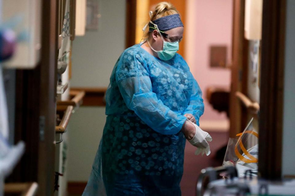 A nurse puts on PPE (personal protective equipment) at the Wren Hall care home in Nottingham (AP)