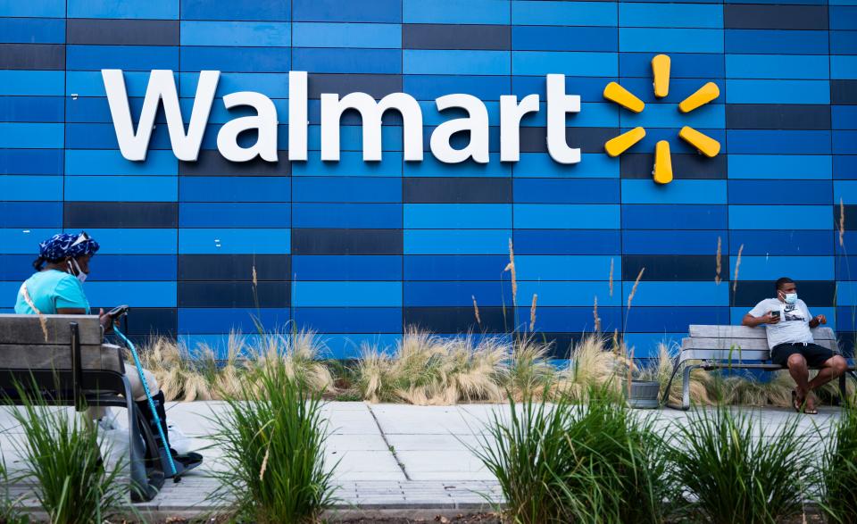 People wearing facemasks sit outside a Walmart store in Washington, DC on July 15, 2020. - Walmart will require shoppers to wear face masks starting next week, the US retail giant announced on July 15, joining an increasing number of businesses in mandating the protection amid the latest spike in coronavirus cases. (Photo by ANDREW CABALLERO-REYNOLDS / AFP) (Photo by ANDREW CABALLERO-REYNOLDS/AFP via Getty Images)