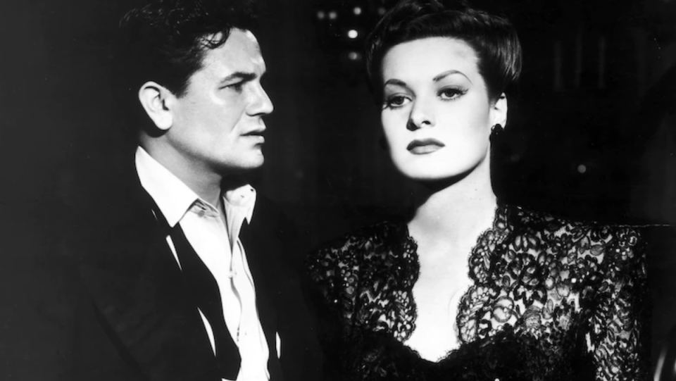 John Garfield looks at Maureen O'Hara in noir film The Fallen Sparrow