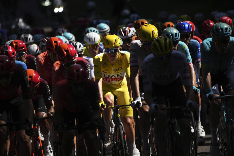 Slovenia's Tadej Pogacar, wearing the overall leader's yellow jersey, rides in the pack during the sixth stage of the Tour de France cycling race over 163.5 kilometers (101.6 miles) with start in Macon and finish in Dijon, France, Thursday, July 4, 2024. (AP Photo/Daniel Cole)