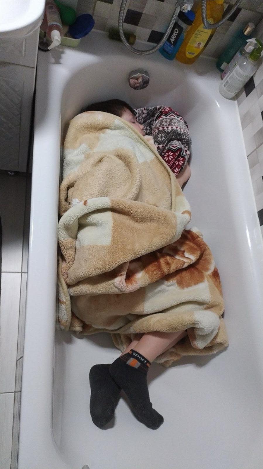 PHOTO: Roman sleeps in a bathtub in Kharkiv, Ukraine, in March 2022, after the Russian invasion of Ukraine began, in a photo supplied by Yana.  (Yana)
