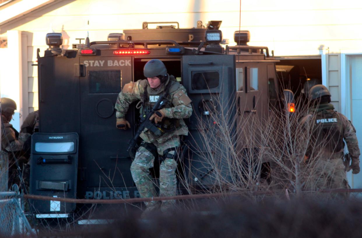 Waterloo police tactical officers arrive at the scene of a standoff in in Waterloo, Iowa, on Wednesday, Jan. 19, 2022. A Wisconsin man accused of killing his girlfriend and trying to kill his teenage daughter in a double shooting in Milwaukee has been arrested following an hourslong standoff in northeastern Iowa.