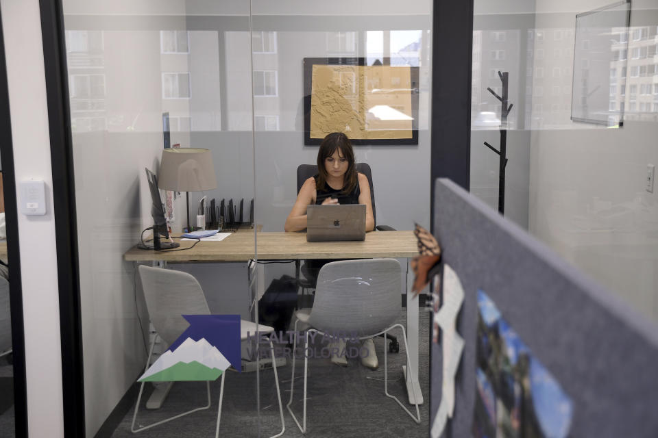 Sabrina Pacha, senior director of Healthy Air & Water Colorado, works in her office in downtown Denver on Monday, July 24, 2023. The organization pushes for public policy focusing on the growing public health threats posed by climate change. (AP Photo/Thomas Peipert)