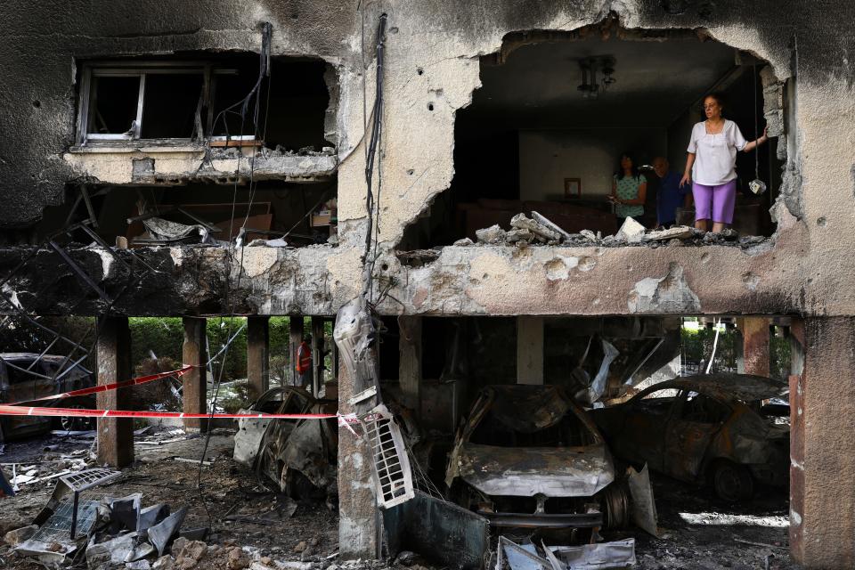 A family inspects the damage to their apartment after it was hit by a rocket fired from the Gaza Strip over night in Petah Tikva, central Israel, Thursday, May 13, 2021.