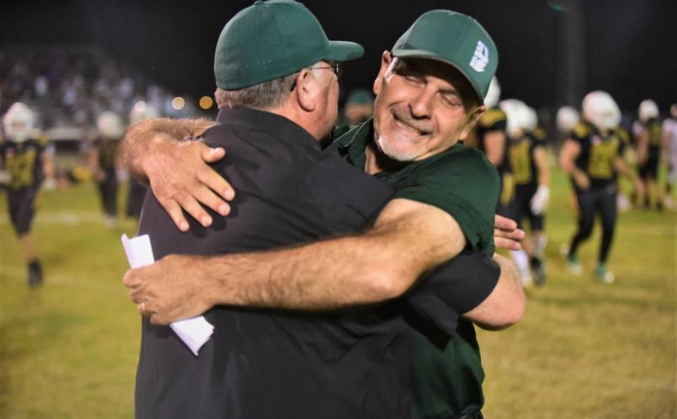 Hilmar High head coach Frank Marques hugs Hilmar athletic director Paul Willis after the Yellowjackets’ emotional 21-20 win over Escalon on Friday, Sept. 30, 2022.