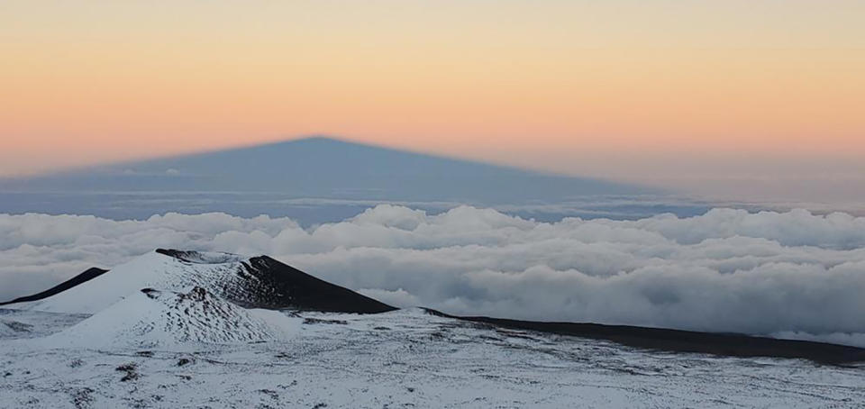 In this photo provided by Center for Maunakea Stewardship, The University of Hawaiʻi Maunakea Rangers rescued a lost hiker found on the Humuʻula Trail Tuesday, Dec. 21, 2021, on the island of Hawaii. Rangers, fire and rescue personnel from the U.S. Army Pohakuloa Training Center, trekked through heavy snow and sleet to find the hiker lost in one of the most dangerous places in Hawaii, after he set off for a hike on Mauna Kea Tuesday morning. The hiker was found Tuesday night in a small cave in “thick white-out conditions" at 13,000 feet above sea level, the center's news release said. (Center for Maunakea Stewardship via AP)