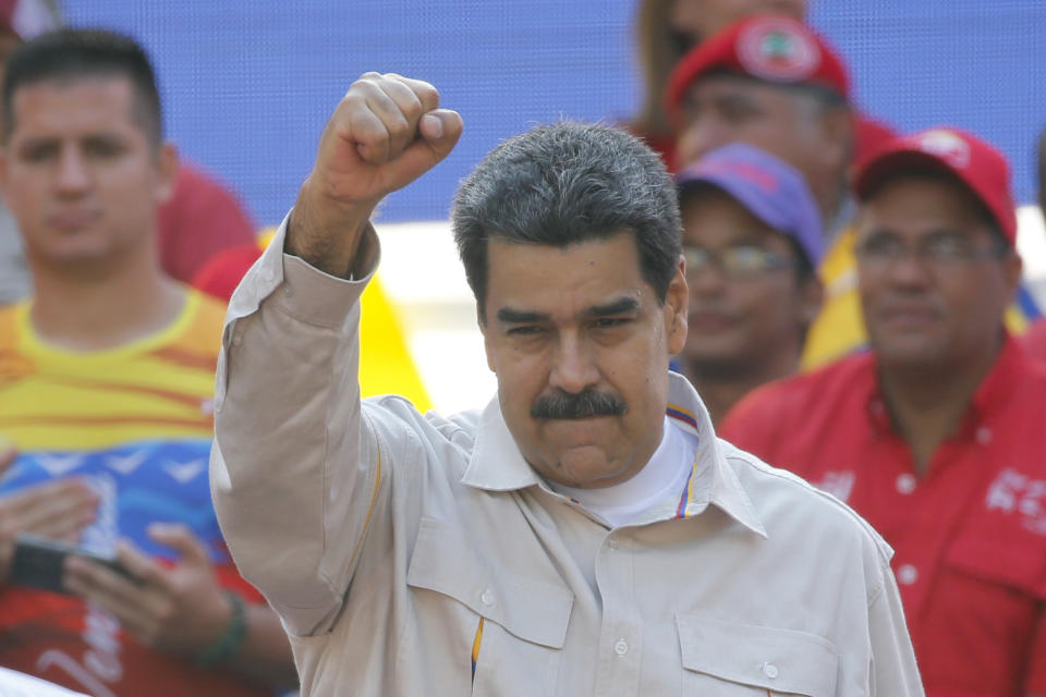 FILE - In this April 6, 2019 file photo, Venezuela's President Nicolas Maduro raises his fist to supporters rallying at the presidential palace in Caracas, Venezuela. The Associated Press has learned on Saturday, June 15, 2019, that major European nations are considering imposing sanctions on Maduro and several top officials for their recent crackdown on political opponents. (AP Photo/Ariana Cubillos, File)