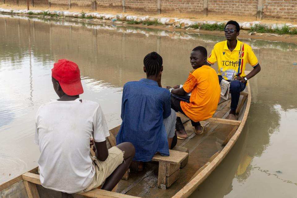 People use a boat to move in a flooded street.