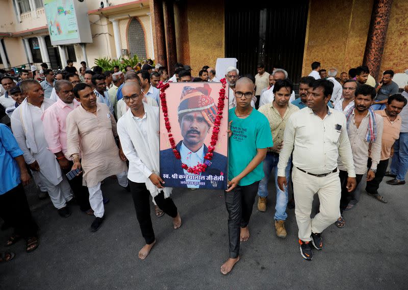 FILE PHOTO: Two sons of Kanhaiyalal Teli, a Hindu tailor, carry a portrait of their father after a prayer meeting in Udaipur