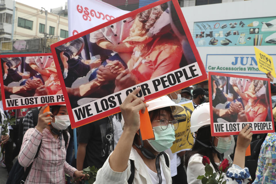 Anti-coup protesters hold an image of Mya Thwet Thwet Khine with a sign that reads "We Lost Our People" during an anti-coup protest rally in Mandalay, Myanmar Saturday, Feb. 20, 2021. Anti-coup protesters in Myanmar's two largest cities on Saturday paid tribute to the young woman who died a day earlier after being shot by police during a rally against the military takeover. (AP Photo)