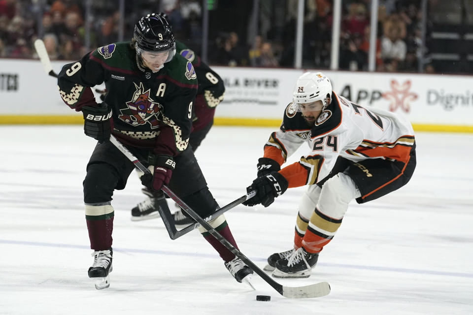 Arizona Coyotes' Clayton Keller (9) controls the puck in front of Anaheim Ducks' Bo Groulx (24) during the first period of an NHL hockey game Saturday, Oct. 21, 2023, in Tempe, Ariz. (AP Photo/Darryl Webb)