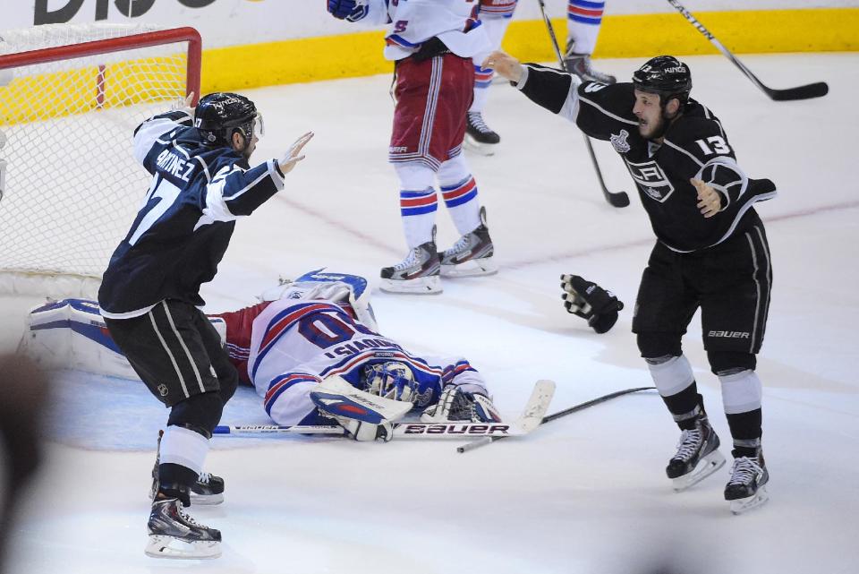 Los Angeles Kings defenseman Alec Martinez, left, celebrates after scoring the winning goal with Kyle Clifford, right, past New York Rangers goalie Henrik Lundqvist, of Sweden, during the second overtime period in Game 5 of an NHL hockey Stanley Cup finals, Friday, June 13, 2014, in Los Angeles. (AP Photo/Mark J. Terrill)