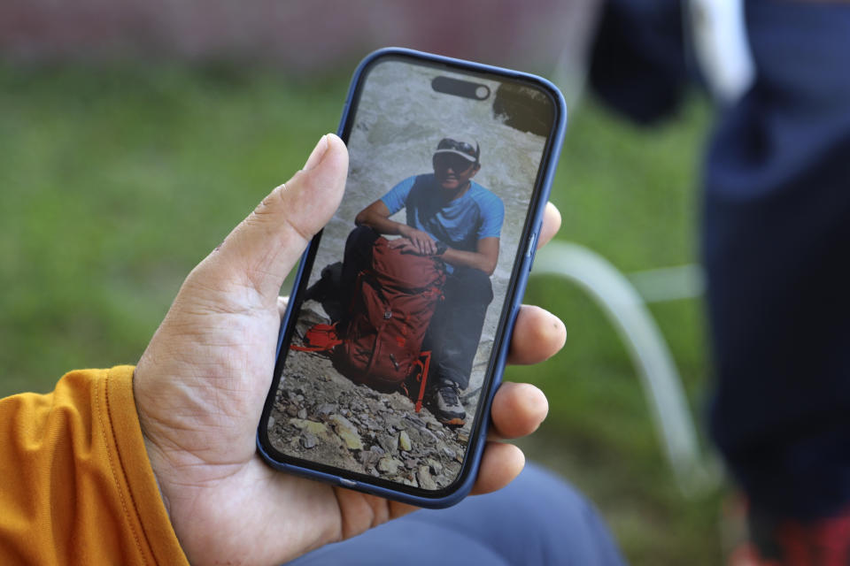 Japanese climber Semba Takayasu shows the picture of fellow climber Shinji Tamura, who was died during summiting highest and unscaled peaks, in his mobile, in Skardu, Pakistan, Tuesday, Aug. 15, 2023. Japanese climber Shinji Tamura died, and his fellow mountaineer Semba Takayasu was injured while trying to scale one of the highest and unscaled peaks in northern Pakistan last week, a mountaineering official and the injured climber said on Tuesday. (AP Photo/M.H. Balti)