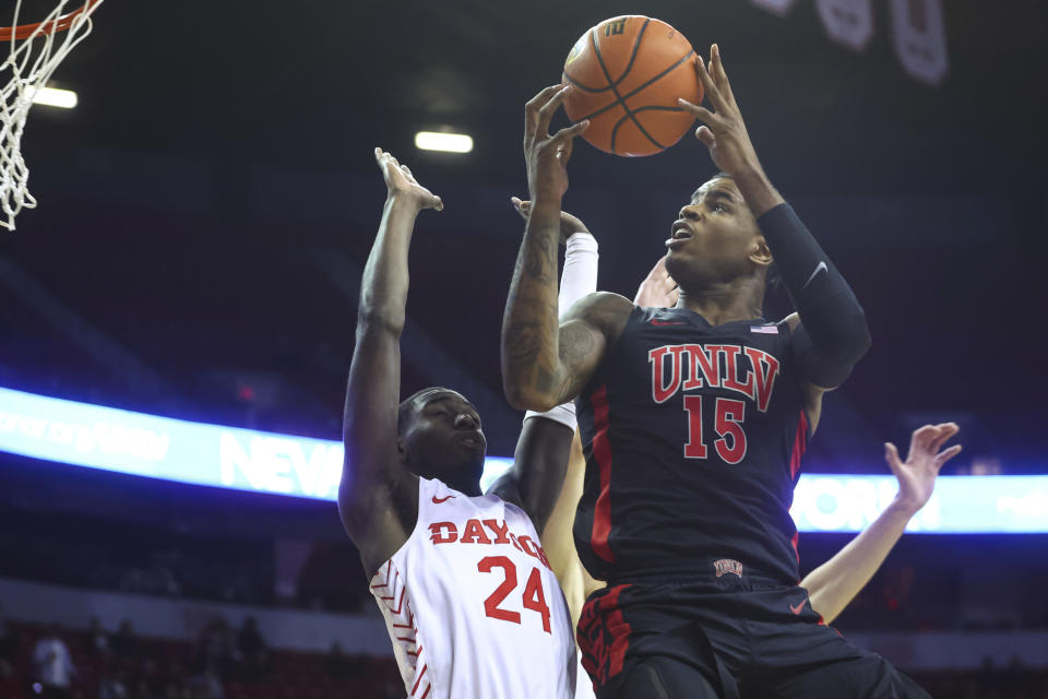 UNLV guard Luis Rodriguez (15) lays up as Dayton's Kobe Elvis (24) guards during the first half of an NCAA college basketball game Tuesday, Nov. 15, 2022, in Las Vegas. (AP Photo/Chase Stevens)