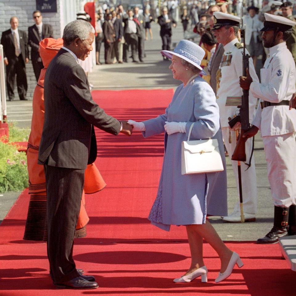 South Africa's President, Nelson Mandela, greets Queen Elizabeth II as she steps from the royal yacht Britannia in Cape Town in 1995. It’s her first visit to the country since 1947 (PA)