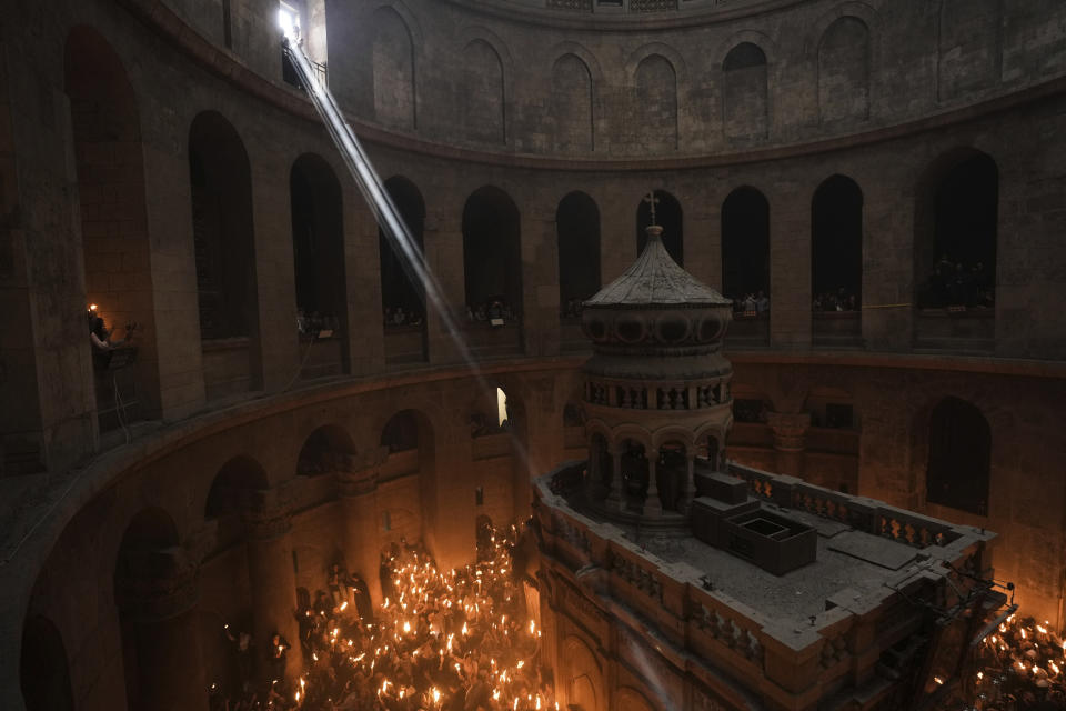 Christian pilgrims hold candles during the Holy Fire ceremony, a day before Easter, at the Church of the Holy Sepulcher, where many Christians believe Jesus was crucified, buried and resurrected, in Jerusalem's Old City, Saturday, April 15, 2023. (AP Photo/Mahmoud Illean)