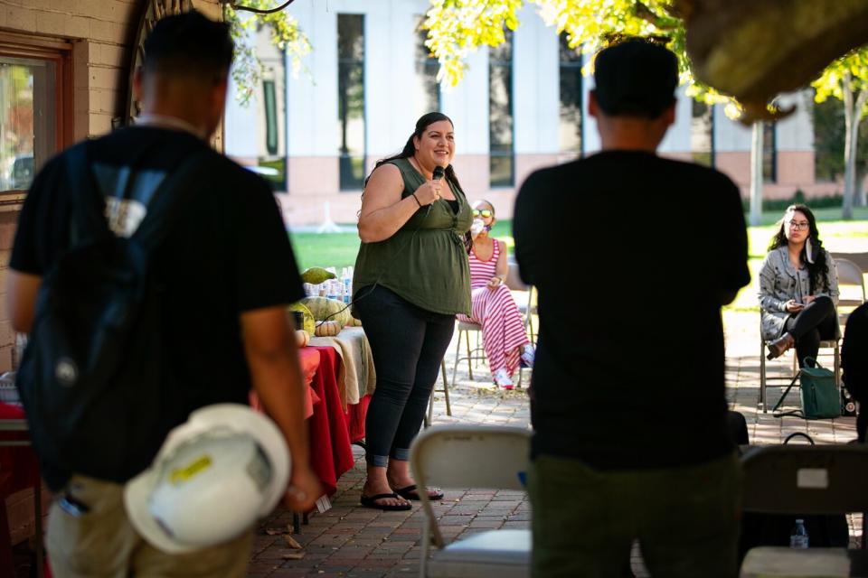 Sara Rodriguez speaks to a crowd with a microphone