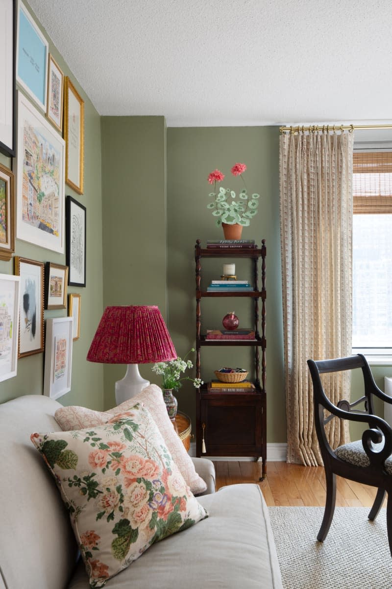 Gallery wall, green walls, floor to ceiling curtains, beige couch and rug, vintage wood chair