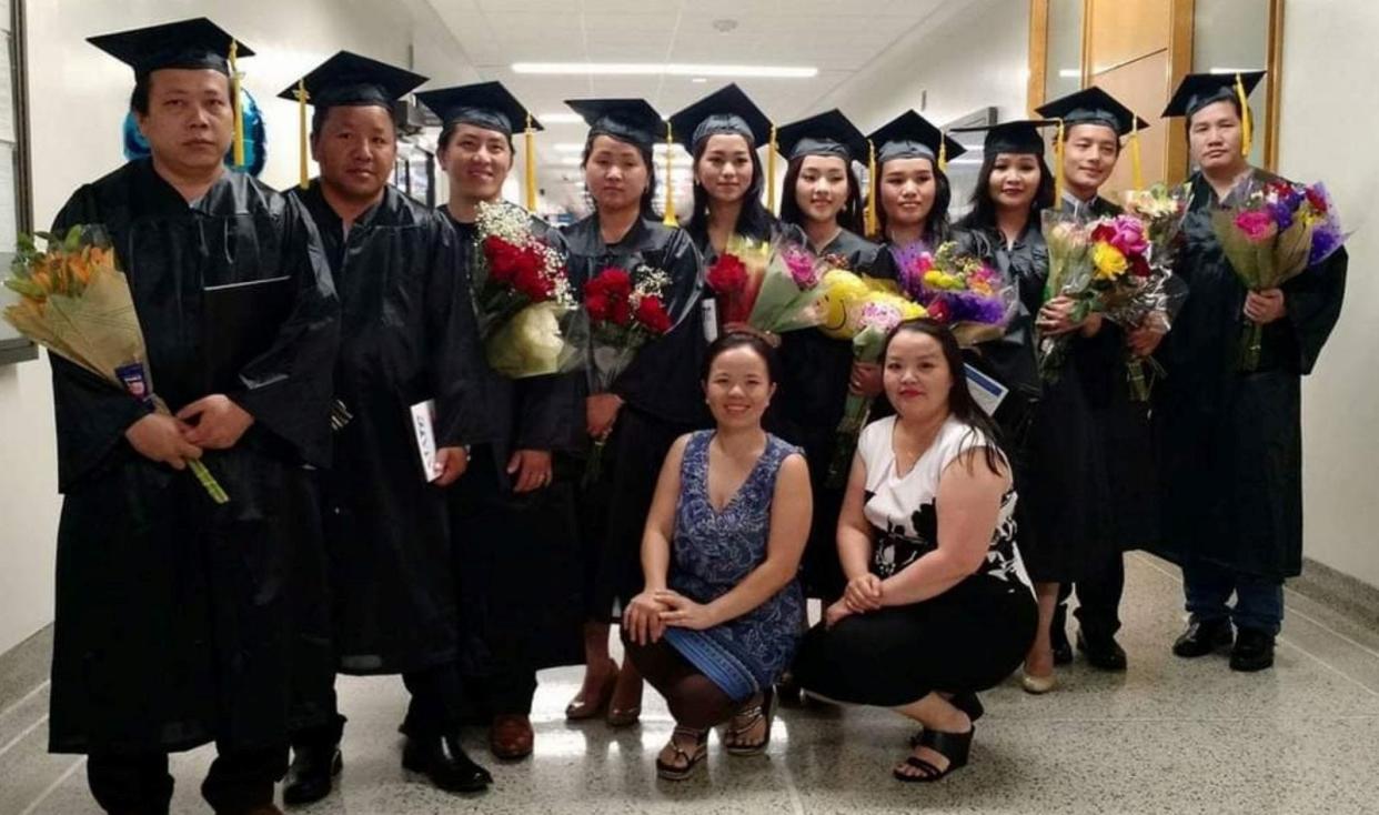 Kou Thao, front left in blue, leads English as a Second Language and high school equivalency classes at Benediction Lutheran Church. She poses along with a volunteer teacher, front right, and several Hmong graduates of the Milwaukee Area Technical College's high school equivalency program.