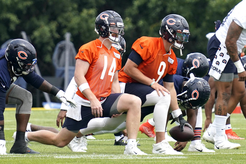 Chicago Bears quarterbacks Andy Dalton (14) and Nick Foles (9) stretch with teammates during NFL football practice in Lake Forest, Ill., Wednesday, July 28, 2021. (AP Photo/Nam Y. Huh)