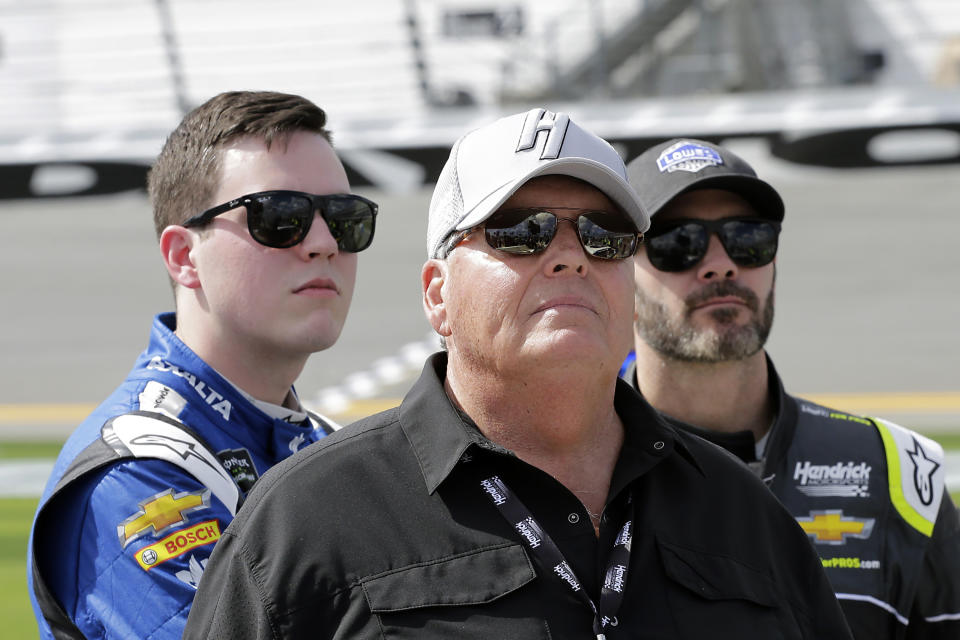 FILE - In this Sunday, Feb. 11, 2018, file photo, car owner Rick Hendrick, front, stands on pit row with drivers Alex Bowman, left, and Jimmie Johnson before qualifying for the NASCAR Daytona 500 auto race at Daytona International Speedway, in Daytona Beach, Fla. The most coveted seat in NASCAR went to Alex Bowman in a Hendrick Motorsports lineup shuffle to replace seven-time champion Jimmie Johnson in the iconic No. 48 Chevrolet. Bowman and crew chief Greg Ives will move from the No. 88 into Johnson's ride at the end of the season. The swap announced Tuesday, Oct. 6, 2020, makes Bowman just the second driver of the team created in 2001 specifically for Johnson. (AP Photo/Terry Renna, File)