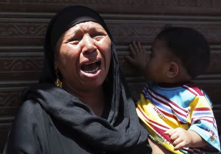 A woman carrying a child cries outside a court in Minya, south of Cairo, after the sentences of Muslim Brotherhood leader Mohamed Badie and his supporters were announced, June 21, 2014.REUTERS/Mohamed Abd El Ghany