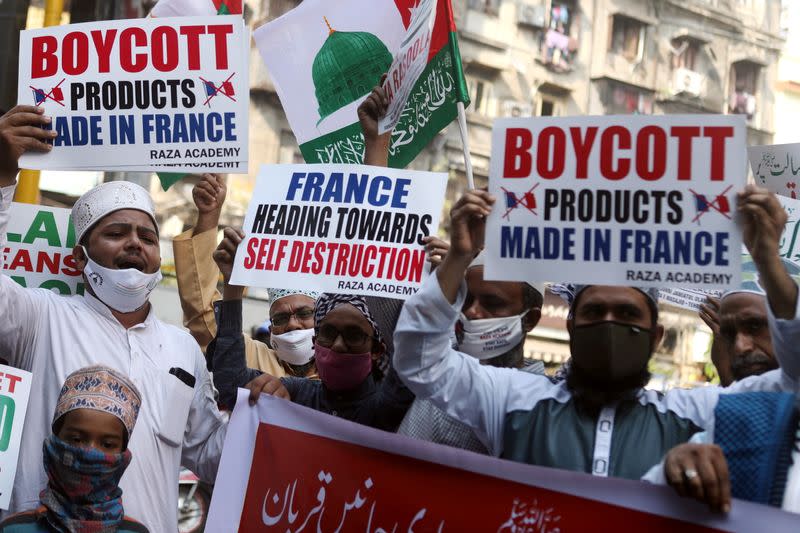 People hold placards and shout slogans during a protest against the publications of a cartoon of Prophet Mohammad in France and Macron's comments, in Mumbai