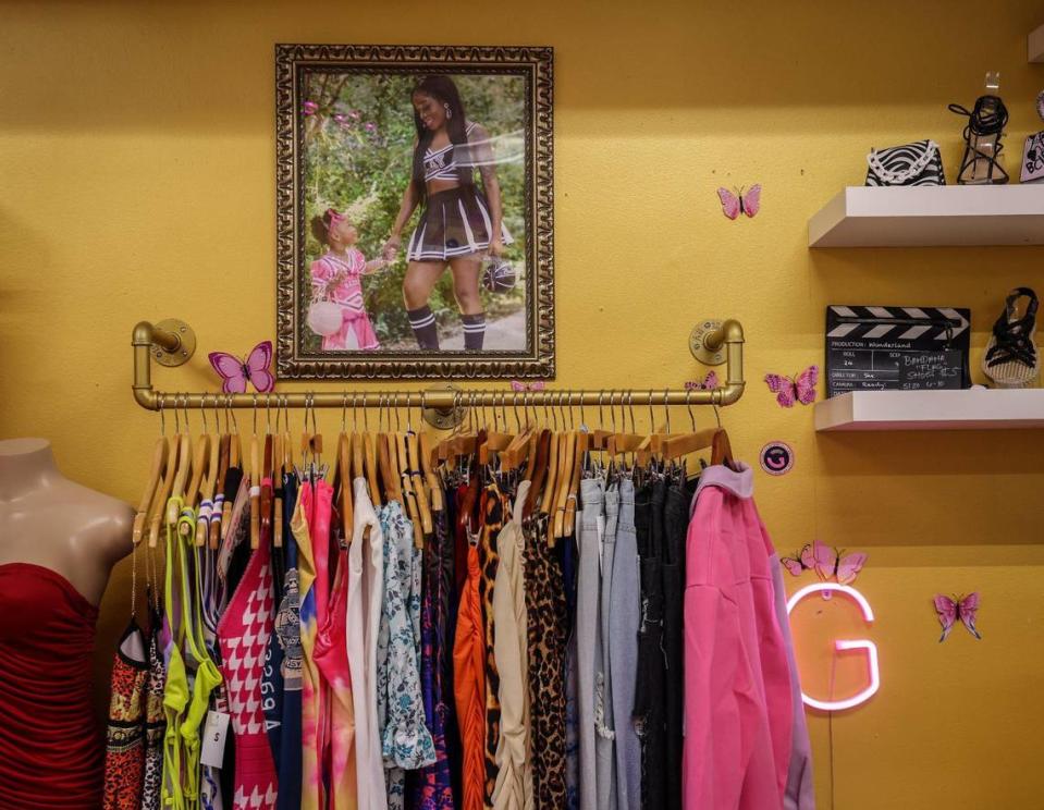 A photo of LaDavia Harrell, 29, and her daughter, Barbie, 2, on the left, is hung over the rack of clothes for sale at Glamour Girl Galore, a Hialeah women’s hair salon and boutique.