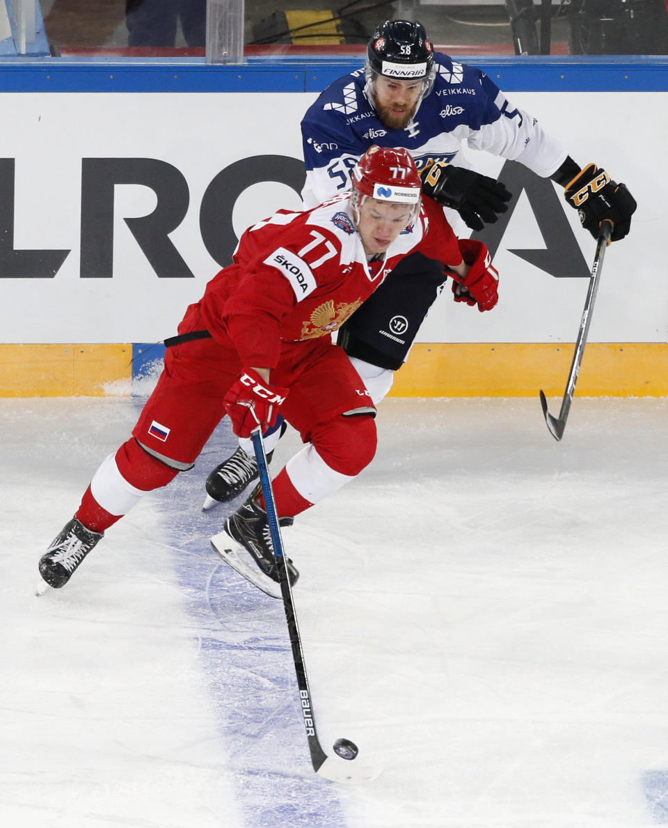 FILE - In this Sunday, Dec. 16, 2018, file photo, Russia's Kirill Kaprizov (77) battles Finland's Jani Hakanpaa (58) during the Channel One Cup ice hockey match in St. Petersburg, Russia. Bonding between veterans and youngsters has been a time-honored tradition in hockey. Older players routinely invite rookies to live with them during their first year. This season, NHL protocols aimed at curbing the spread of COVID-19 could make team-building more difficult. (AP Photo/Dmitri Lovetsky, File)