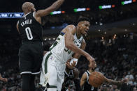 Milwaukee Bucks' Giannis Antetokounmpo (34) is defended by Brooklyn Nets' Jevon Carter (0) during the first half of an NBA basketball game Tuesday, Oct. 19, 2021, in Milwaukee. (AP Photo/Morry Gash)