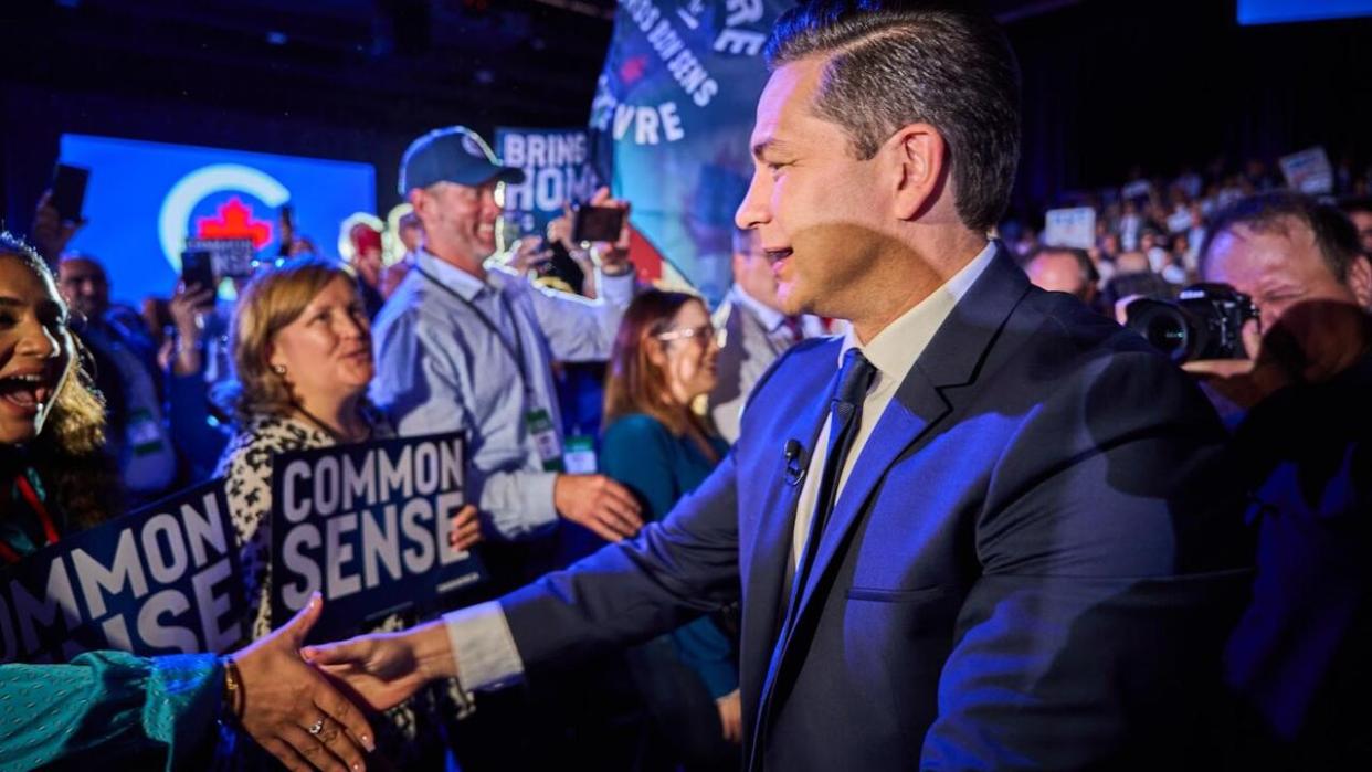 Conservative Leader Pierre Poilievre shakes hands with delegates as he walks to the stage to speak at the party's policy convention in Quebec City on Sept. 8, 2023. (David Richard/Radio-Canada - image credit)