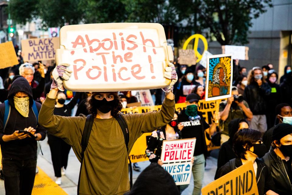 OAKLAND, CALIFORNIA - JULY 25:  Protesters hold signs in support of defunding the police on July 25, 2020 in Oakland, California. Demonstrators in Oakland gathered to protest in solidarity with Portland protests. (Photo by Natasha Moustache/Getty Images)