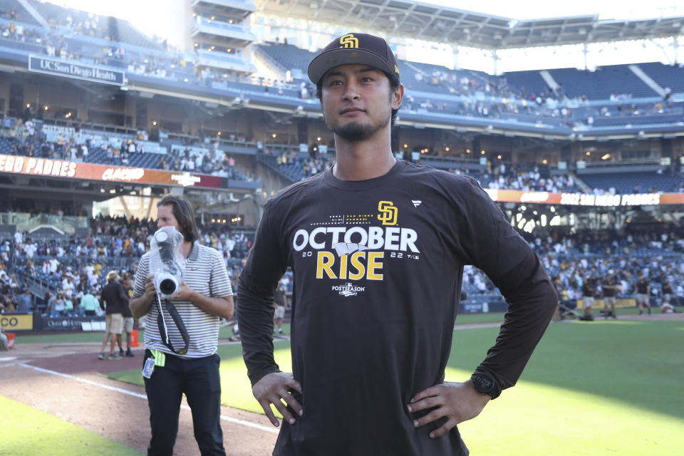 San Diego Padres' Yu Darvish looks on as teammates celebrate following a baseball game against the Chicago White Sox after clinching a wild-card playoff spot, Sunday, Oct. 2, 2022, in San Diego. (AP Photo/Derrick Tuskan)