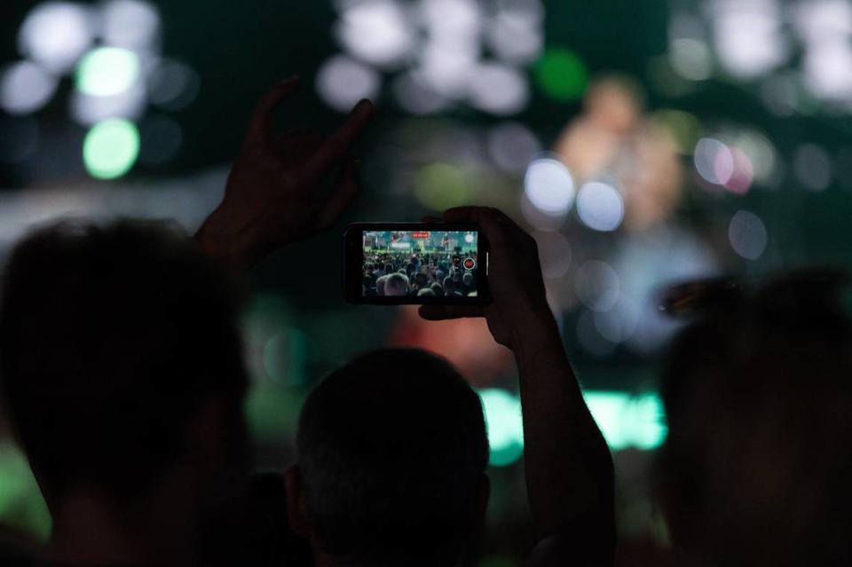 A fan records Foo Fighters’ performance with their cell phone at PNC Music Pavilion in Charlotte on Thursday night.