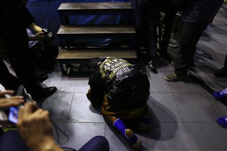 A fighter prays before entering the ring during the closing Thai boxing, or "Muay Thai", fight night of the legendary Lumpinee stadium, one of Bangkok's oldest boxing venues which is being demolished after 57 years, February 7, 2014. REUTERS/Damir Sagolj