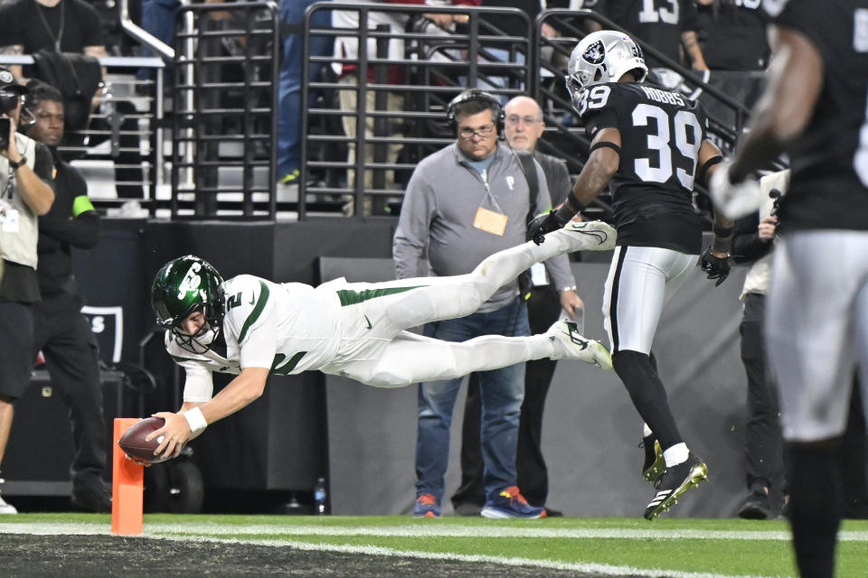 New York Jets quarterback Zach Wilson, right, dives for the end zone as Las Vegas Raiders cornerback Nate Hobbs (39) watches during the first half of an NFL football game Sunday, Nov. 12, 2023, in Las Vegas. Wilson stepped out of bounds just short of the goal line before the dive. (AP Photo/David Becker)