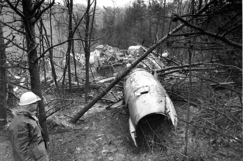 FILE - In this Nov. 15, 1970, file photo, a fireman looks over the wreckage of a DC-9 jet that was carrying 75 people including 26 members of the Marshall University football team, in Kenova, W.Va. Marshall and East Carolina will open the 2020 football season a week earlier to accommodate a national television broadcast to mark the 50th anniversary of the worst disaster in U.S. sports history. (AP Photo/File)