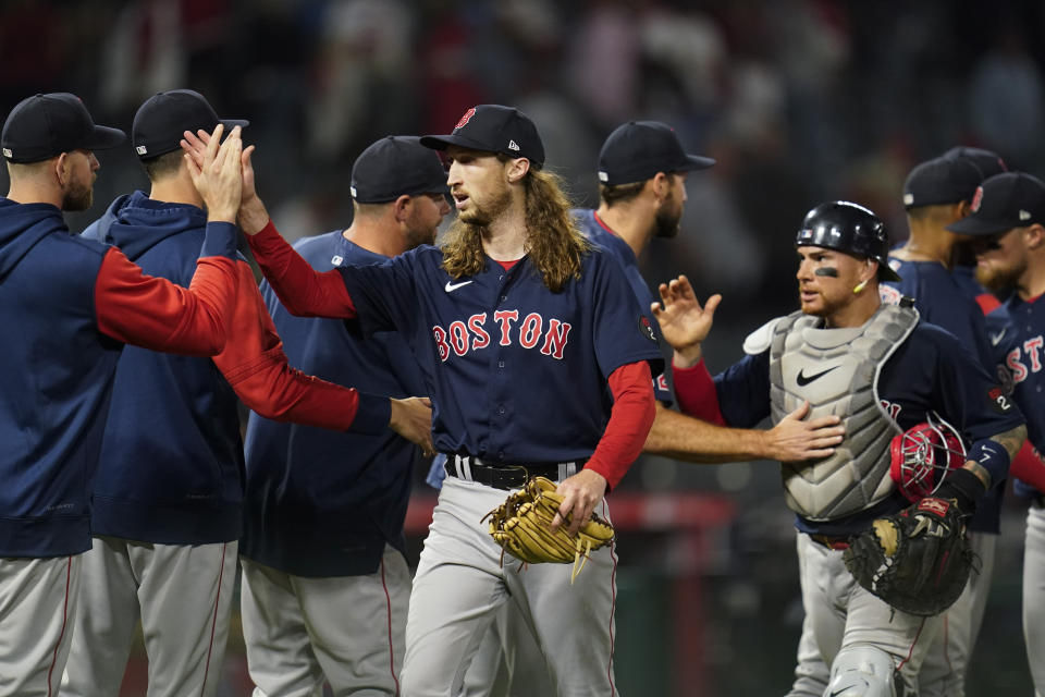 Boston Red Sox relief pitcher Matt Strahm, center, celebrates with teammates after a 6-5 win over the Los Angeles Angels in a baseball game in Anaheim, Calif., Tuesday, June 7, 2022. The Red Sox won in the 10th inning. (AP Photo/Ashley Landis)