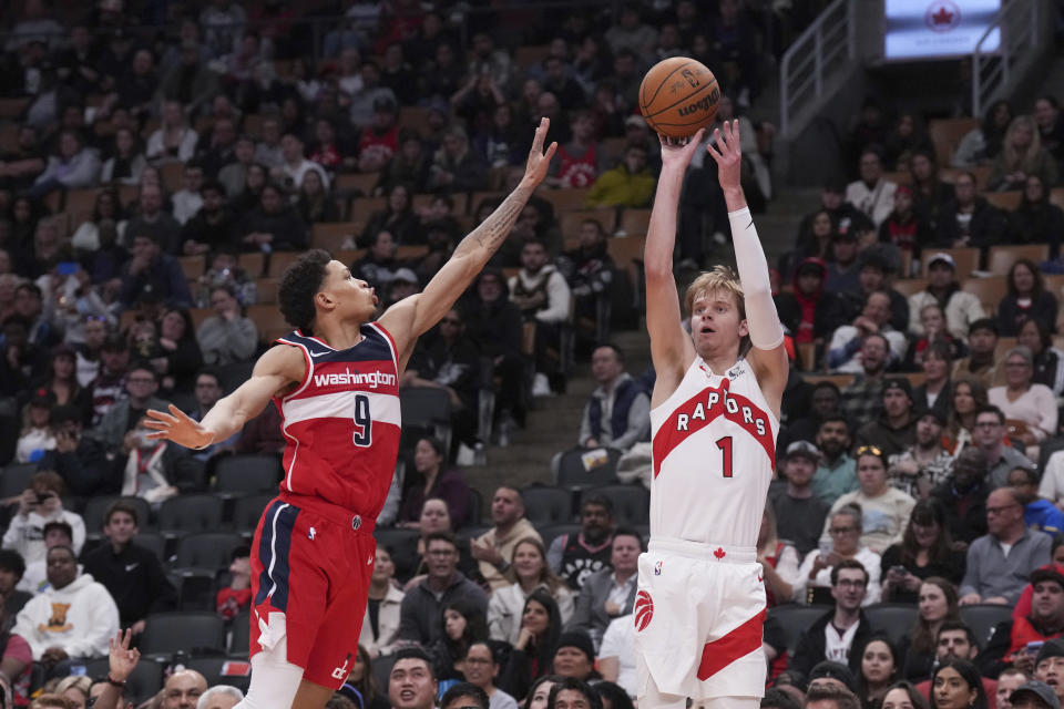 Toronto Raptors' Gradey Dick (1) shoots as Washington Wizards' Ryan Rollins (9) defends during second-half preseason NBA basketball game action in Toronto, Friday Oct. 20, 2023. (Chris Young/The Canadian Press via AP)